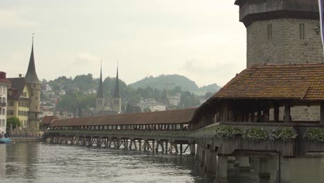 historical wooden covered kapellbrucke bridge and water tower in reuss river, church of st