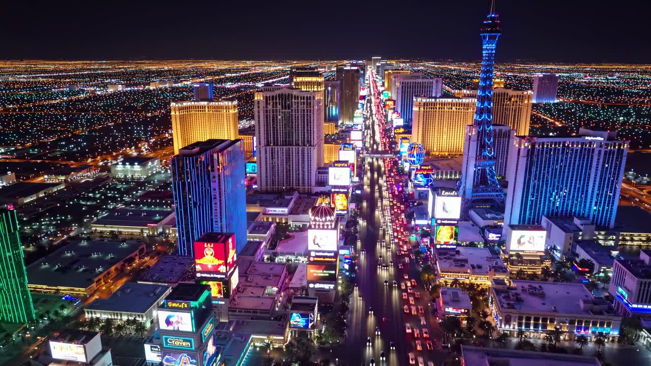 Aerial view of a vibrant cityscape at night, showcasing illuminated skyscrapers and bustling