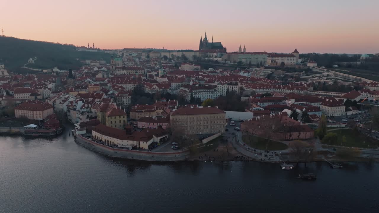 Panoramica cinematografica a sinistra che mostra il Castello di Praga, il fiume Moldava e il Ponte Carlo al tramonto.