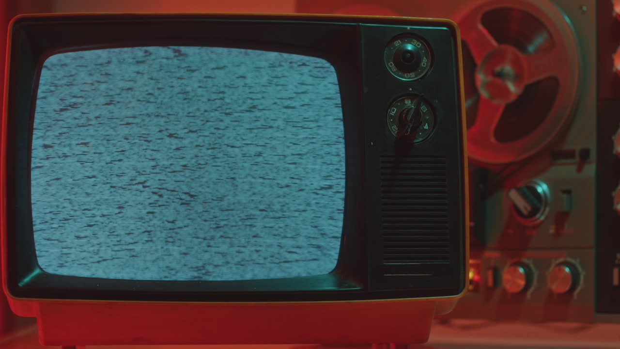 Retro Analog TV Set with Static Noise on Display in Dark Room with Neon Light