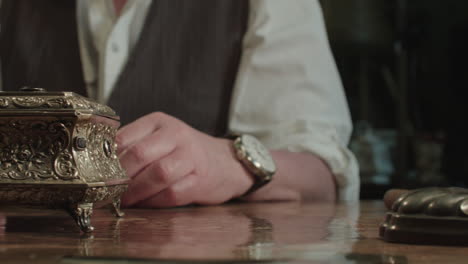 an older man opens antique gold box
