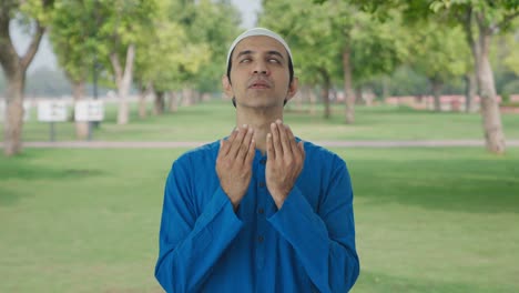 faithful muslim man reading namaz in park