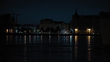 night view of city buildings reflected in water