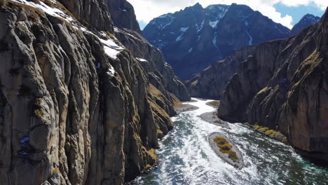 majestic river flowing through a deep canyon with snowy peaks