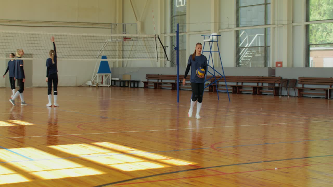 Volleyballhold træner i et gymnasium