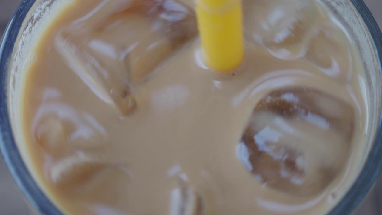 Primo piano di un caffè freddo shakerato con una cannuccia gialla