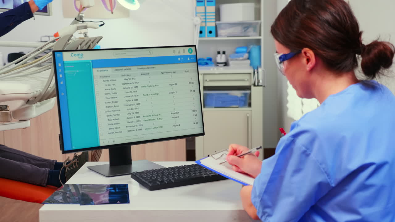 enfermera ortodontista mirando la lista con las citas tomando notas