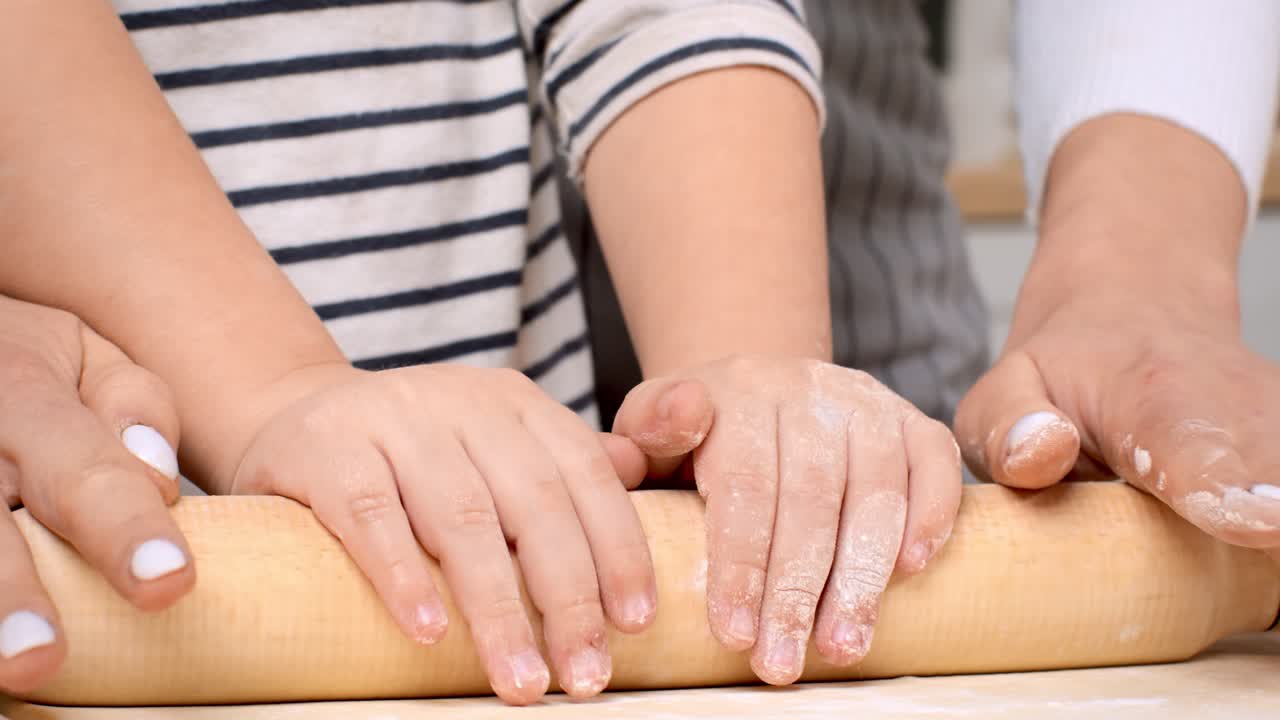 아이들이 반죽을 굴리는 데 도움을 줍니다.