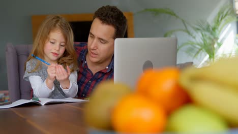 Father-helping-girl-in-her-studies-in-living-room-4k