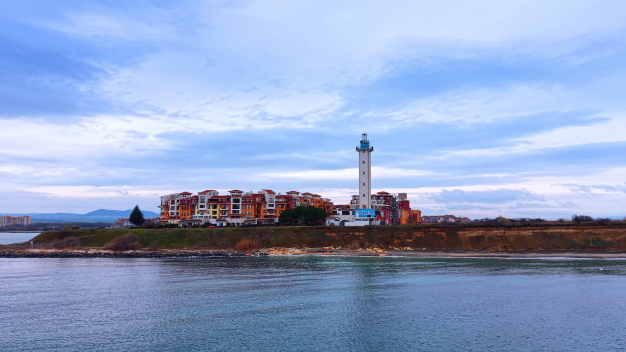Vista panoramica di un faro e di un resort su una scogliera costiera. Ampia prospettiva aerea di un faro e di edifici residenziali situati su una scogliera sopra il mare
