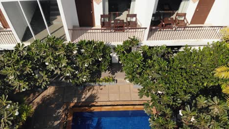 Drone-Tilt-Shot-From-Hotel-Rooms-with-Balconies-to-Reveal-the-Tropical-Hotel-Swimming-Pool