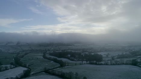 aerial tracking sideways through a misty cold and snowy field scene