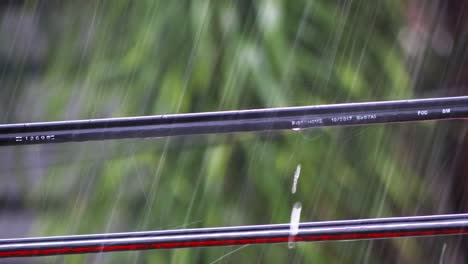 beads of rainwater run down the length of utility cables strung between poles