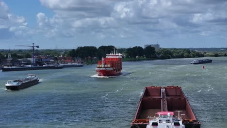 Moviendo-Basura-Vacía-Y-Buque-De-Carga-En-El-Río-En-Zwijndrecht,-Seguimiento-Aéreo