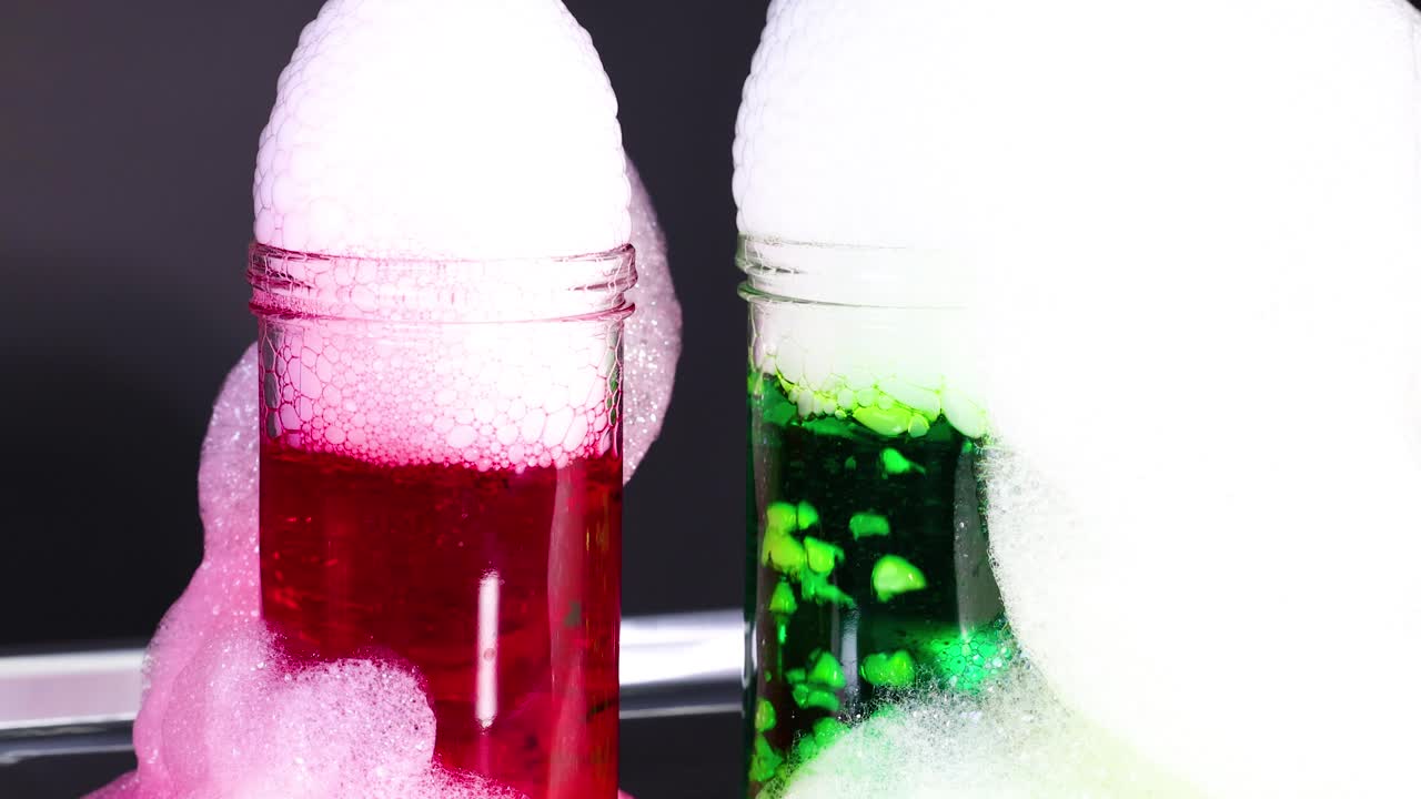 건조 얼음으로 생동감 넘치는 과학 실험은 빨간색과 녹색 액체에서 다채로운 거품을 만들어 화학 반응을 보여줍니다.