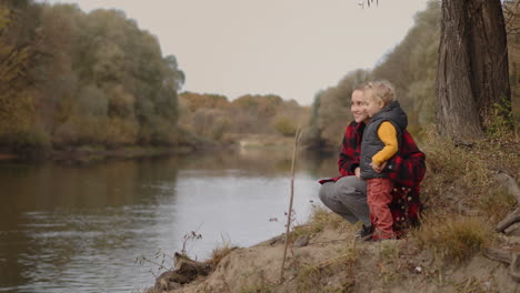 Fröhliches-Familienwochenende-Im-Herbst.-Frau-Mit-Kleinem-Kind-Genießt-Die-Waldlandschaft-Mit-See.-Mutter-Erzieht-Ihren-Kleinen-Sohn-Und-Erklärt-Ihm-Glück-Und-Ruhe