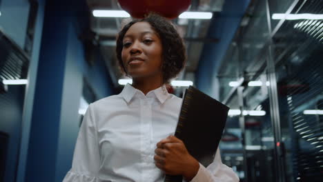 afro business woman waving hand in business center. woman saying hi in office