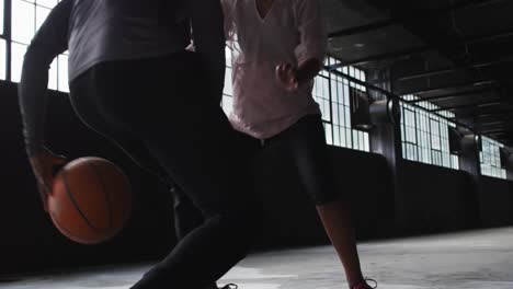 African-american-man-and-woman-standing-in-an-empty-building-playing-basketball