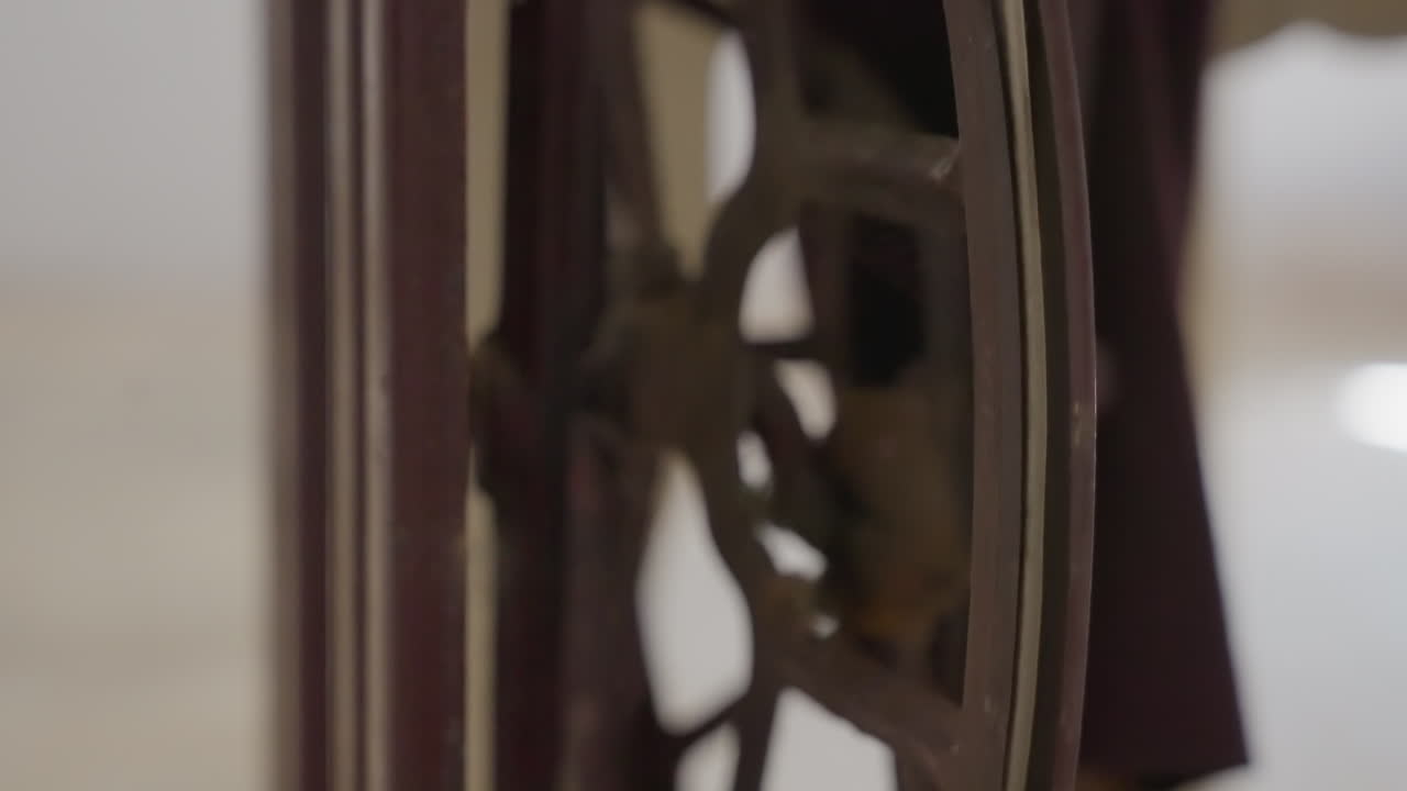 Closeup vintage sewing wheel black cloth, intimate indoor scene showing antique flywheel beside dark fabric, soft warm light on wooden frame, slow rotation suggesting careful mending by tailor, mood