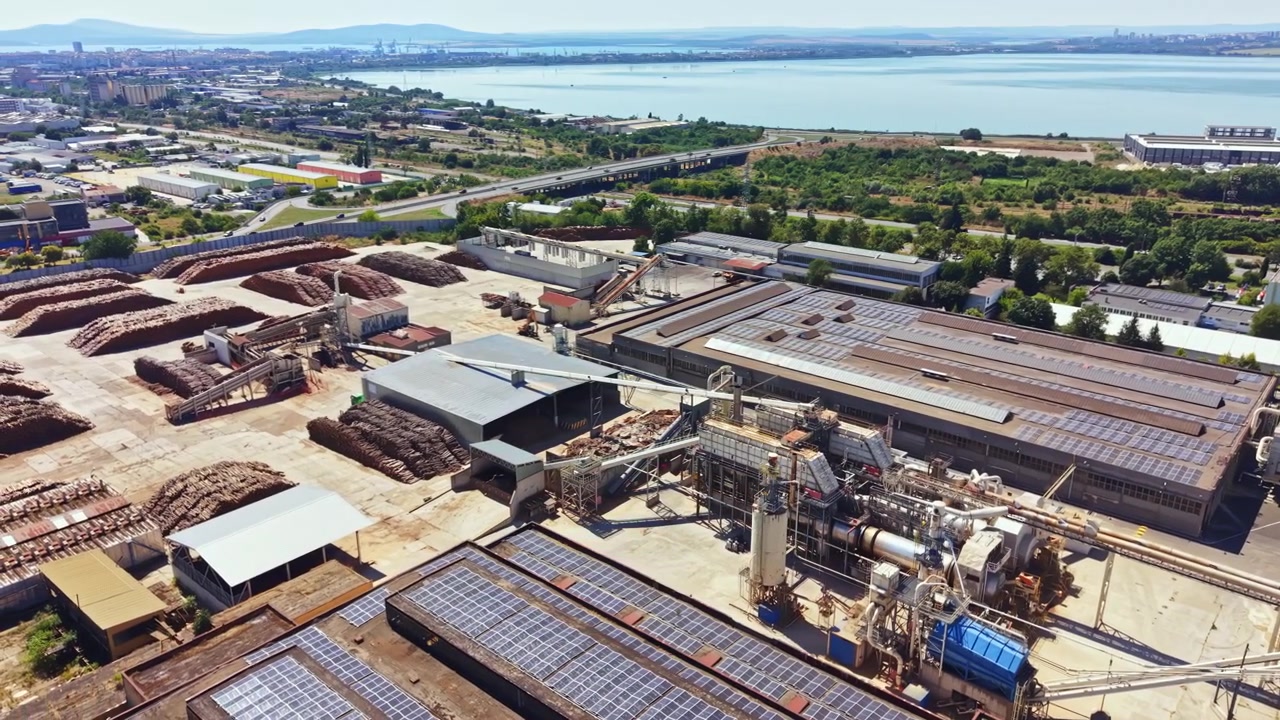 Large industrial site with solar panels near waterfront during daylight