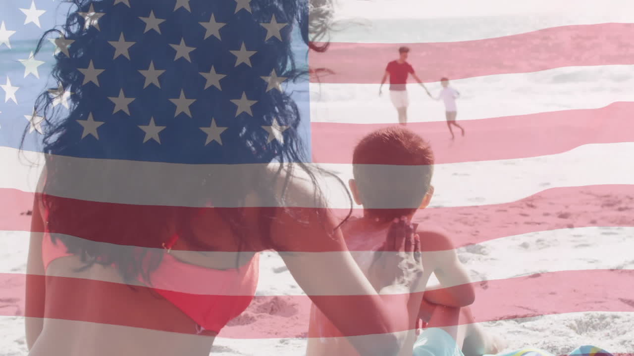 animación de la bandera de los estados unidos de américa sobre una pareja biracial con niños a orillas del mar