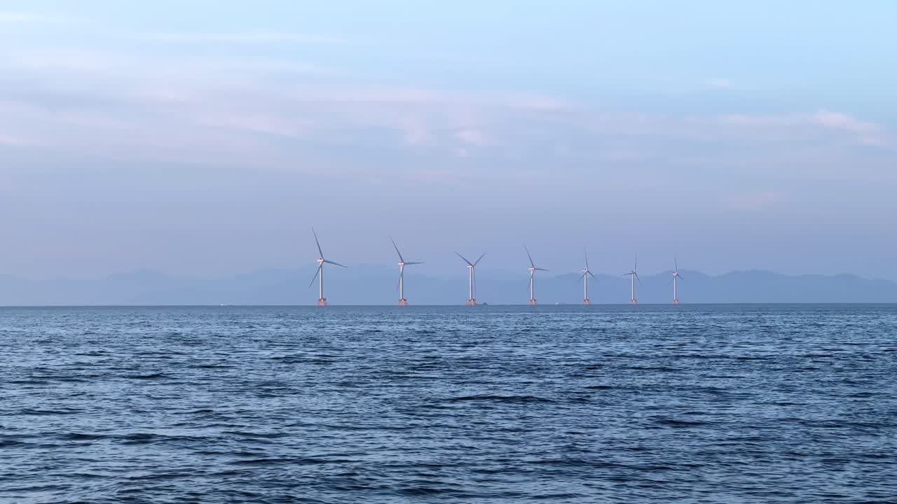 Offshore wind turbines on calm sea near Otaru Dream Beach at peaceful twilight hour