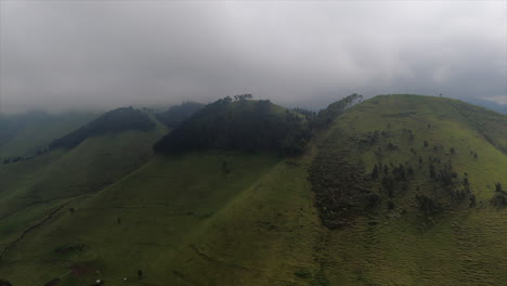 Pesado-Bajo-Nublado-En-Vuelo-Aéreo,-Colinas-De-Hierba-Verde-Del-Valle-Del-Rift