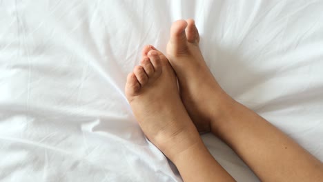 child's feet on a white bed