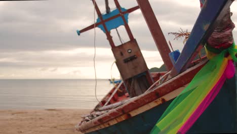 Nahaufnahme-Dolly-Schuss-Von-Hölzernen-Thailändischen-Fischerboot-Am-Strand,-Während-Des-Sonnenaufgangs