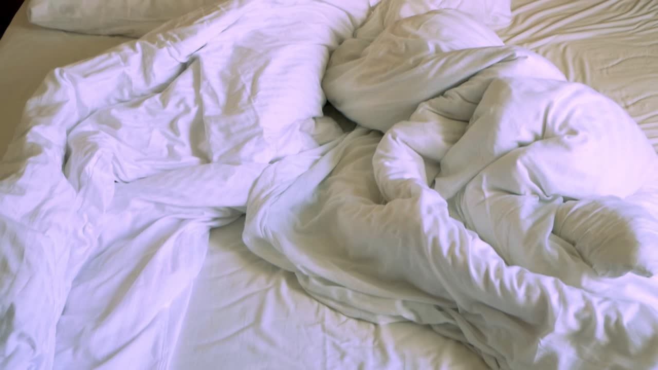 toma panorámica de la cama de hotel desordenada después de una gran noche