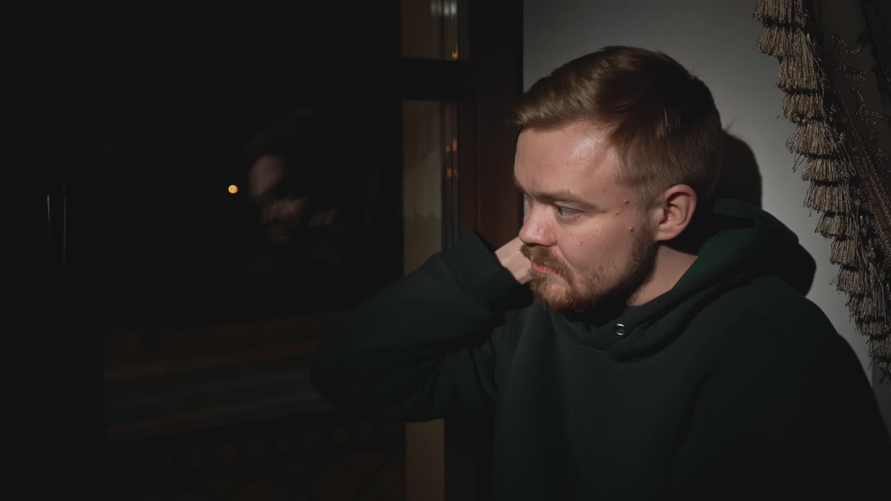 печальный человек у окна ночью