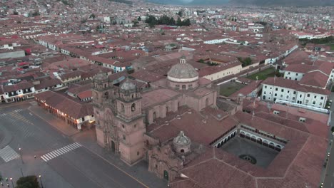 4k daytime aerial drone footage with the church of the society of jesus from plaza de armas in cusco, peru during coronavirus lockdown