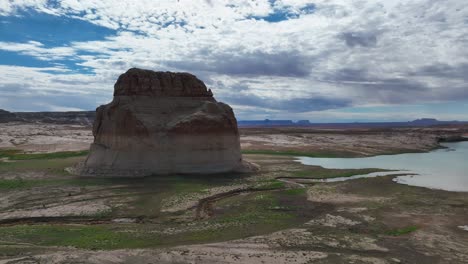 large distinctive rock formation lone rock during drought in man-made lake powell on the border of arizona and utah