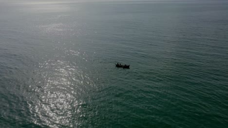 vista aérea de la silueta del barco flotando en el mar arábigo con reflejo de la luz del sol