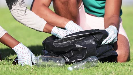 close-up view of people picking garbage in bag