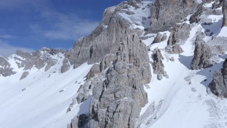 hermosa toma de avión no tripulado que se eleva sobre las montañas nevadas de italia revelando una gran cordillera en los alpes italianos