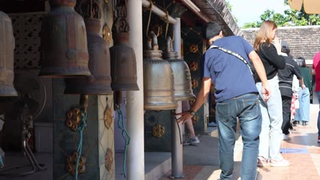 individuals ringing bells in a temple setting