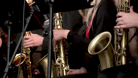 cerca de mujer músico tocando la trompeta y el saxofón en el escenario