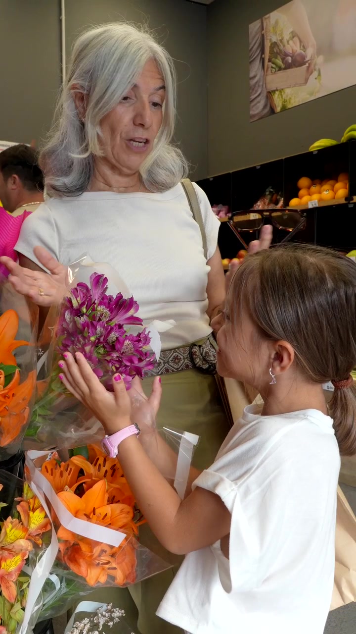 Avó e neta escolhendo flores em um mercado