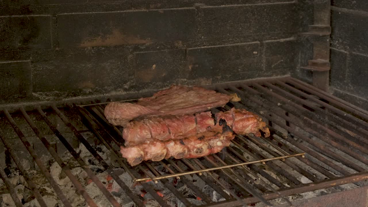 Primo piano di carne sulla griglia in un barbecue in pietra.