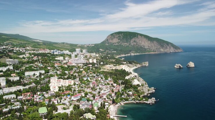 Vista panoramica aerea sulla città turistica di Gurzuf e sul Monte Orso, Ayu-Dag, Yalta, Crimea. Giornata di sole primaverile. Sfondo naturale estivo con mare e spiaggia. Concetto di vacanza, viaggio e tempo libero.