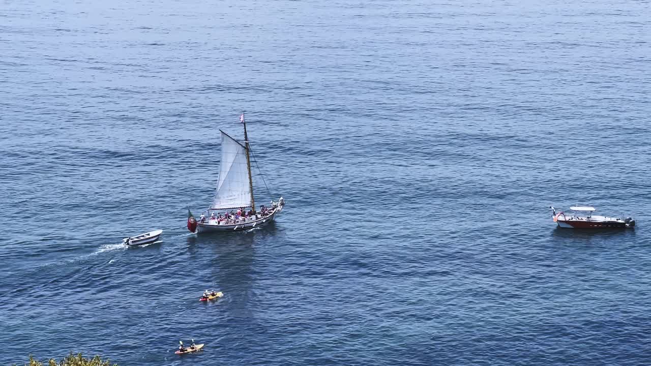Detailed close up shot of a sailing boat moving on the Algarve coast in Portugal with clear blue water