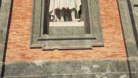 a statue gradually revealed on a building facade