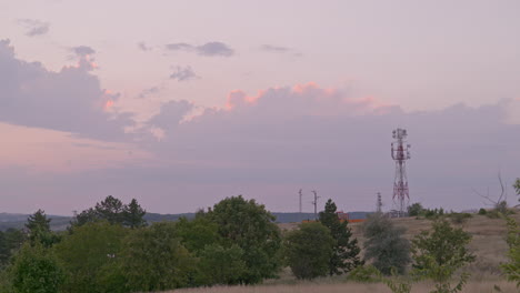 sunset with communication tower silhouetted against magenta colour sky