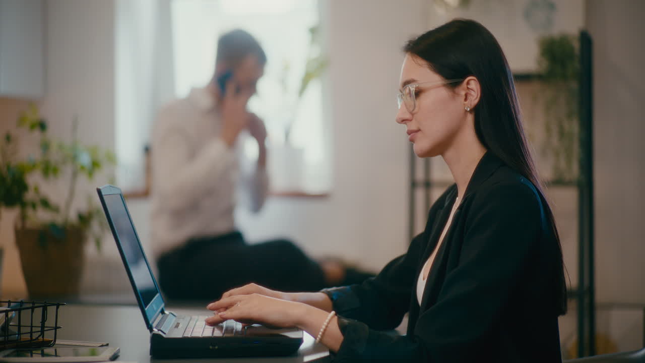 사업가 여성이 직장에서 노트북으로 일하고 있습니다.