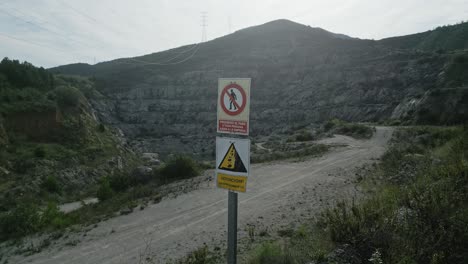 warning signs blocking quarry entrance highlighting falling rocks danger, preventing unauthorized personnel access and emphasizing industrial workplace safety precautions, spanish language
