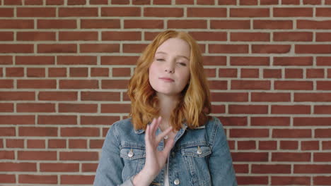 portrait-of-beautiful-red-head-woman-looking-confident-on-brick-wall-background-running-hand-through-hair