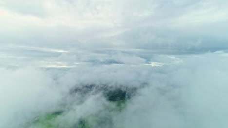 floating slowly through clouds with a glimpse of green land underneath