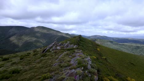 aerial drone footage following a rocky summit trail in a beautiful mountain range