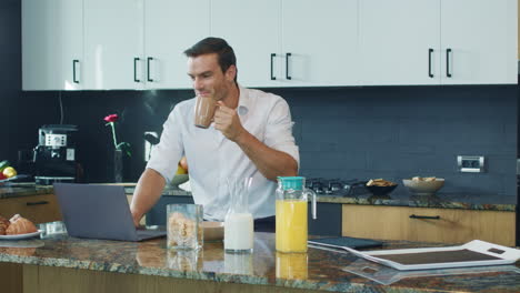 hombre de negocios viendo video de pie en la cocina grande